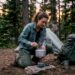 Backpacker cooking with portable stove at dusk